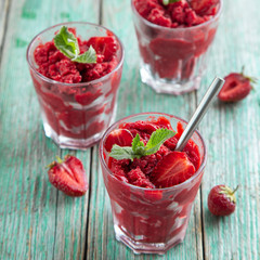 strawberry sorbet ice cream in a glass, green wooden background