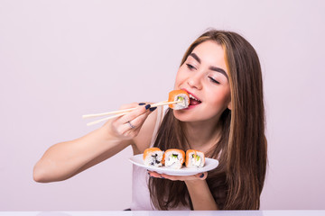Young pretty woman eat sushi with a chopsticks, isolated on white background