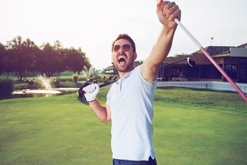 Happiness winner man golfer putting a golf ball in to hole
