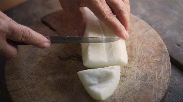 Winter melon get split into pieces with knife. Ingredient for cooking soup.