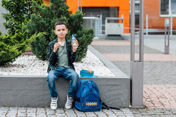 Cute school boy holding lunch box. Healthy eating concept for schoolchild.