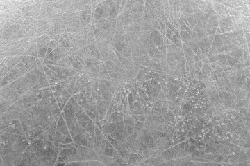 Silver shiny scratched background with water drops. Close-up view.