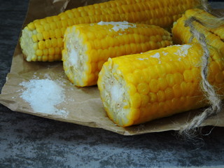 Fresh juicy boiled corn in paper. Warm boiled corn and salt.