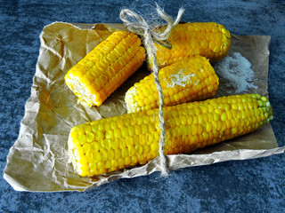 Fresh juicy boiled corn in paper. Warm boiled corn and salt.