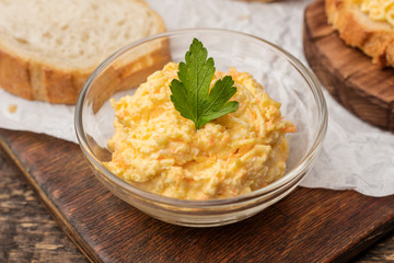 Bowl with grated cheese and garlic sauce on the table, decorated with basil leaves. Close up