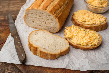 Cooking a grated cheese sandwich with garlic on a piece of white loaf. Cooking Snacks