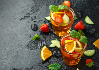 Refreshing Pimms Cocktail with Fruit and vegetables on rustic black table