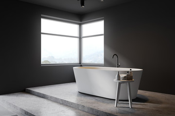 Gray bathroom corner with tub and window
