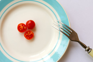Plate with cherry tomatoes. Concept of hard dieting and weight loss.