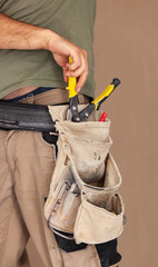 Worker uses tool belt, authentic and real moment.