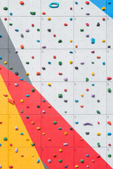 Abstract colorful of rock climbing wall with toe and hand hold studs.