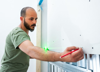 Worker building plasterboard wall.
