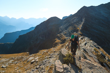 Female hiker on a narrow ridge in the mountains. Via Alta Verzasca, Switzerland.