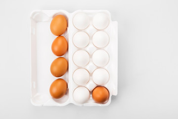 Group of raw eggs white and brown. Concept of diversity, isolation, racism, inequality. On gray background. Top view