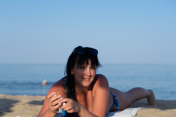 Beautiful brunette woman 35 years old resting on the beach by the sea.