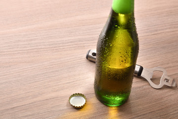 Green bottle with alcoholic beverage on wood table elevated