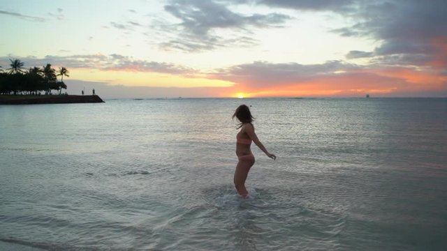 Slow Motion: Fit Young Woman in Bikini Spins in Kauai Ocean at Sunset, Kauai, Hawaii