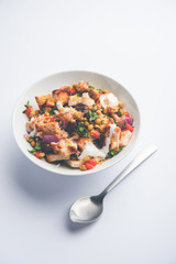 Bread chaat/chat is a yummy starter/appetizer from India, served in a bowl garnished with tomato, sev and coriander and masala. selective focus