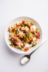 Bread chaat/chat is a yummy starter/appetizer from India, served in a bowl garnished with tomato, sev and coriander and masala. selective focus