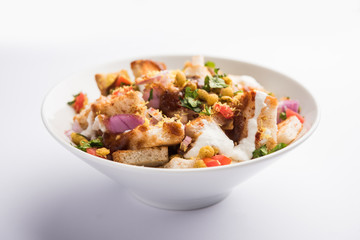 Bread chaat/chat is a yummy starter/appetizer from India, served in a bowl garnished with tomato, sev and coriander and masala. selective focus