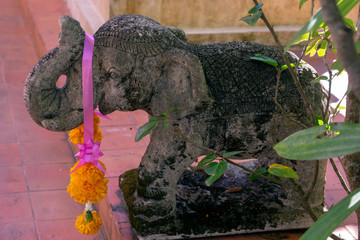 Carved stone elephant in garden, Wat Phra Kaew, Chiang Rai, Thailand