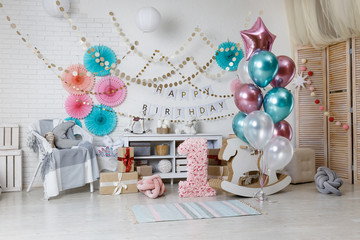 A large bunch of balloons pink and green. Birthday pink and teal decorations with gifts, toys, garlands and candy for yearling little baby party on a white background.