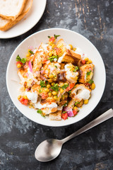 Bread chaat/chat is a yummy starter/appetizer from India, served in a bowl garnished with tomato, sev and coriander and masala. selective focus