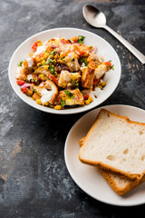 Bread chaat/chat is a yummy starter/appetizer from India, served in a bowl garnished with tomato, sev and coriander and masala. selective focus