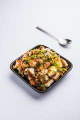 Bread chaat/chat is a yummy starter/appetizer from India, served in a bowl garnished with tomato, sev and coriander and masala. selective focus