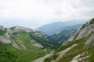 Fototapeta na wymiar Pilatus mountain range in the Swiss Alps, Lucerne. Panoramic view from the height between the mountains to the green valley.