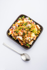 Bread chaat/chat is a yummy starter/appetizer from India, served in a bowl garnished with tomato, sev and coriander and masala. selective focus