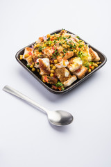 Bread chaat/chat is a yummy starter/appetizer from India, served in a bowl garnished with tomato, sev and coriander and masala. selective focus