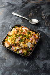Bread chaat/chat is a yummy starter/appetizer from India, served in a bowl garnished with tomato, sev and coriander and masala. selective focus