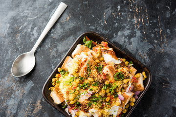 Bread chaat/chat is a yummy starter/appetizer from India, served in a bowl garnished with tomato, sev and coriander and masala. selective focus