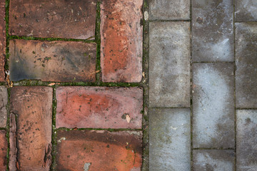 Old and new - red bricks and gray cement blocks flooring