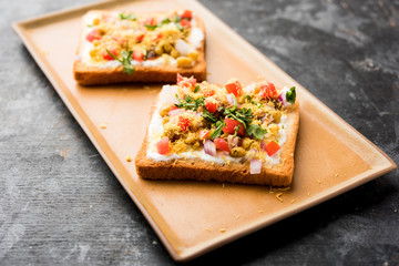 Bread ppadi chaat/chat is a yummy starter/appetizer from India, served in a plate garnished with tomato, sev and coriander and masala. selective focus