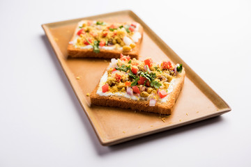 Bread ppadi chaat/chat is a yummy starter/appetizer from India, served in a plate garnished with tomato, sev and coriander and masala. selective focus