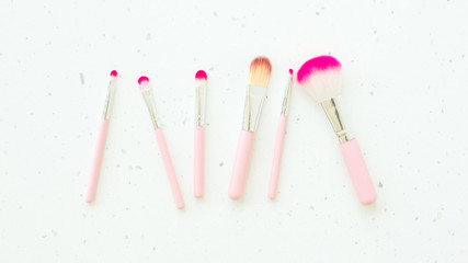 Makeup brushes on white background. Set of golden makeup brushes, concept. Woman beauty accessory in pastel colors. Flat lay
