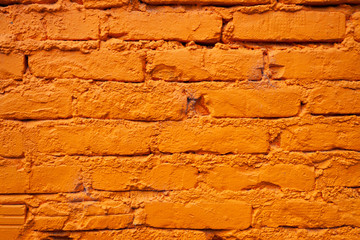 Detail of a brick wall painted in vivid orange