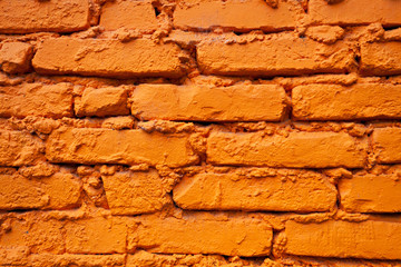 Detail of a brick wall painted in vivid orange
