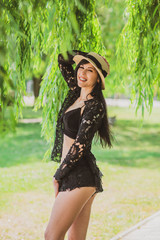 Young sexy woman with long dark hair wearing fashionable black lace suit. Concept of vacation and relax time 