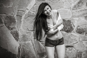 Young modern sexy woman with long dark hair wearing fashionable white shirt and shorts. Concept of fashion  