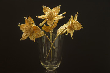 Bouquet of flowers made of straw in a glass vase
