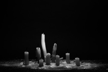 Mourning concept. The white candle that has been extinguished on black background. Selective focus.