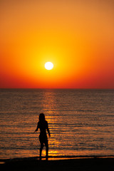 woman watching the sunset on the beach. the concept of a healthy lifestyle