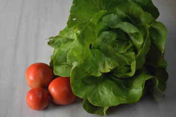 Lechuga y tomates ecologicos en un fondo de piedra