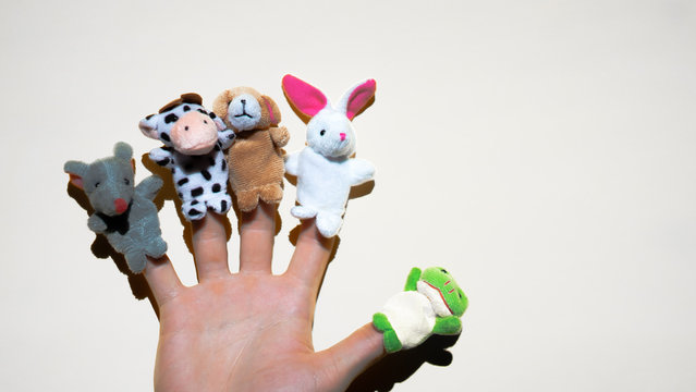 Puppet theater of doll  animals. Hand wearing finger puppets: rat, frog, dog, rabbit, cow, mouse. animal finger puppets show.