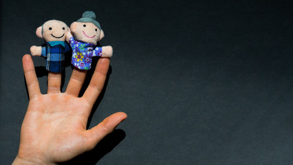 Puppet theater. Hand wearing old people members puppets: elderly granny and grandpa. happy...