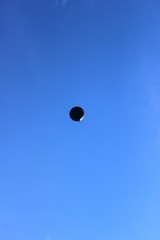 A large balloon flies high in the sky.