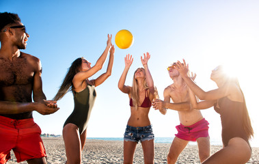 Group of friends playing at beach volley at the beach